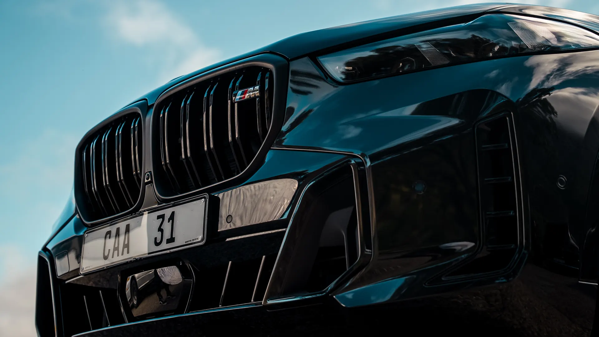 A black BMW X5 photographed low from the front against a dramatic Cape Town sky, from the SOHO VIP Protection shoot