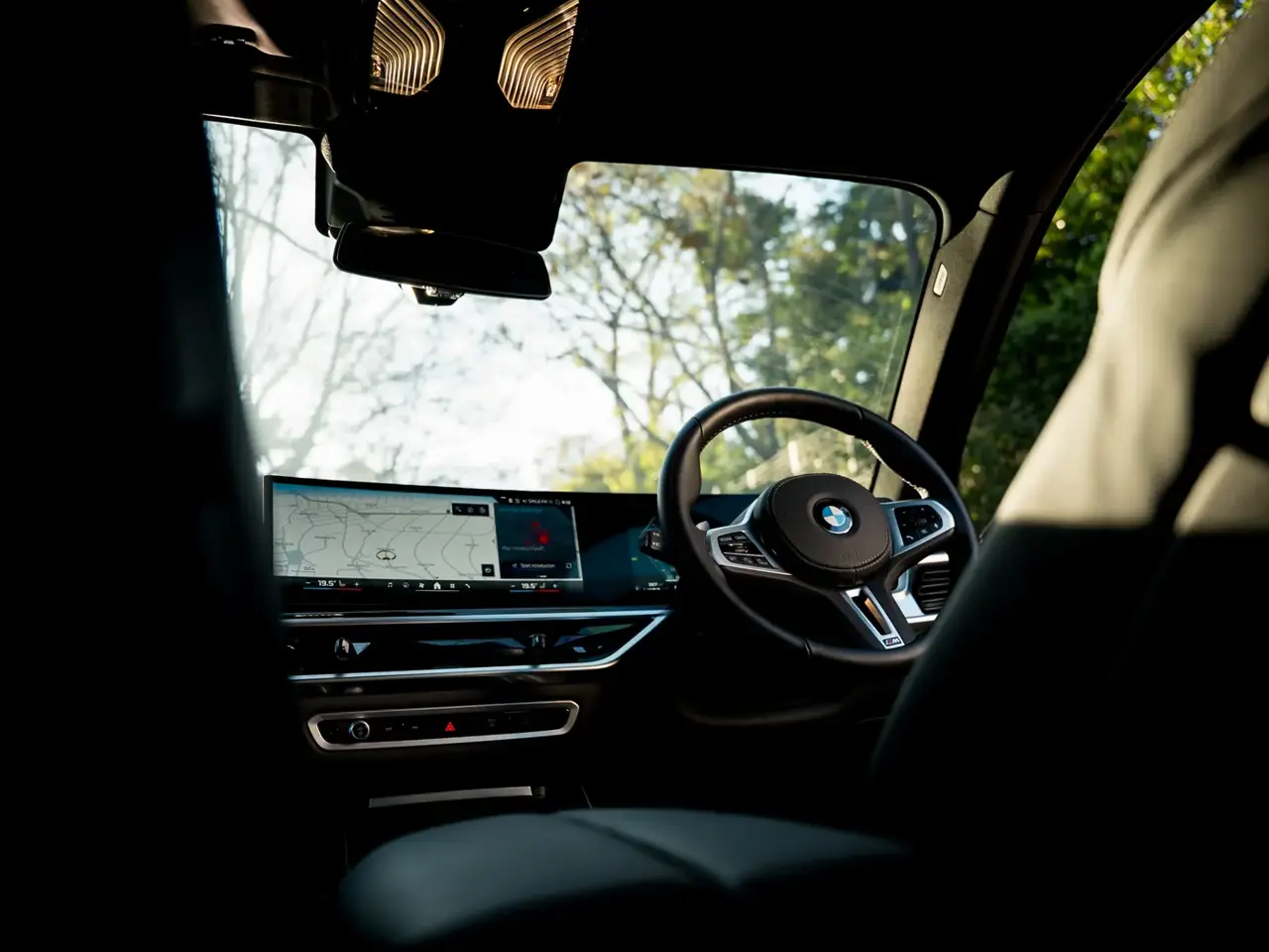 Driver seat and steering wheel, sun flaring through the windscreen
